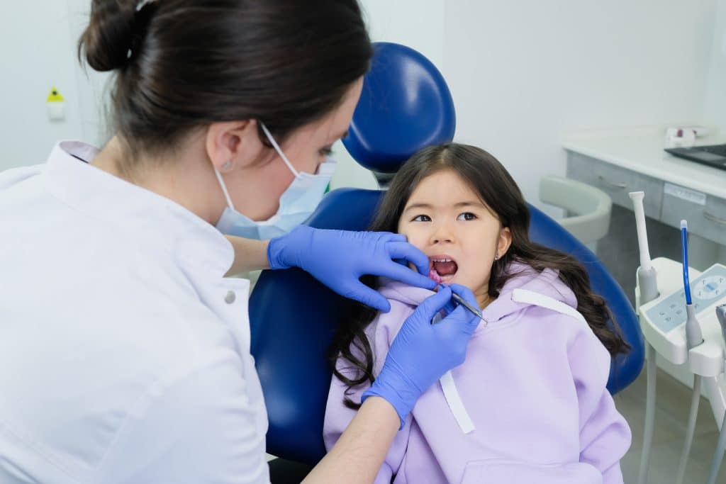 Autism dentist this image shows a dentist cleaning a young girl's teeth