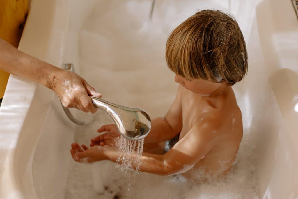 parent helping their autistic child feel secure throughout bath time