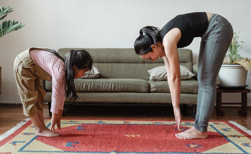 exercise at home for kids. a kid and their parent are doing exercises at home to stay healthy.