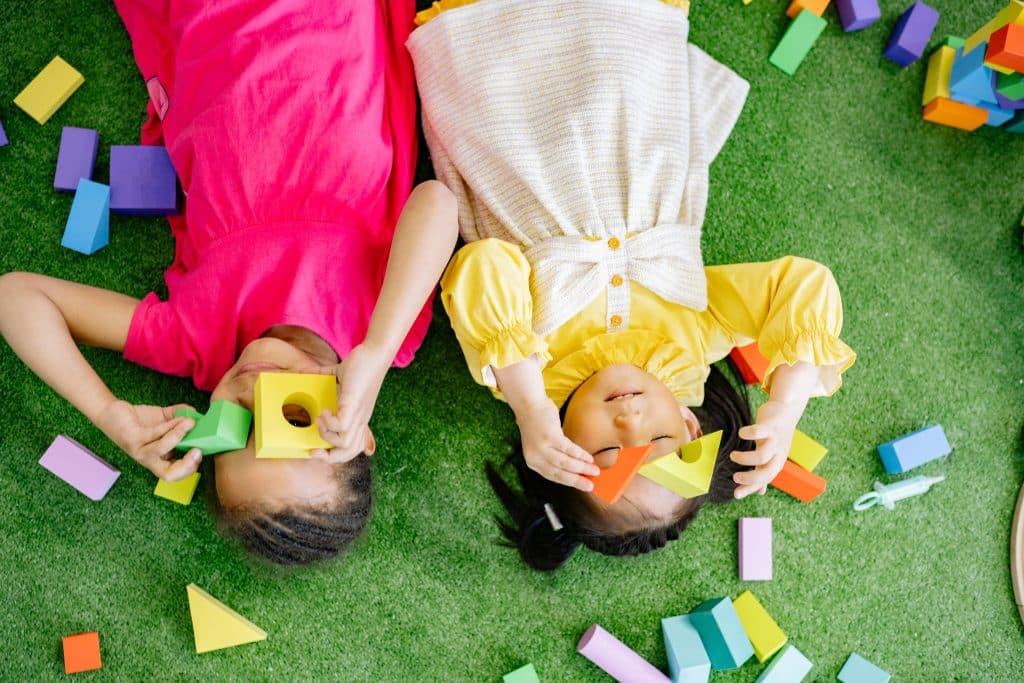 Gifts for Autistic Kids this image shows children playing with toys while laying down