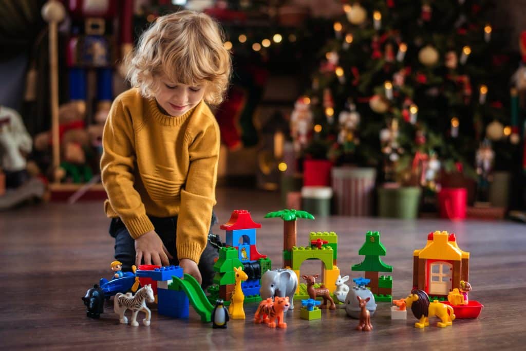 Gifts for kids with ADHD this image shows a little boy playing with LEGO and other toys