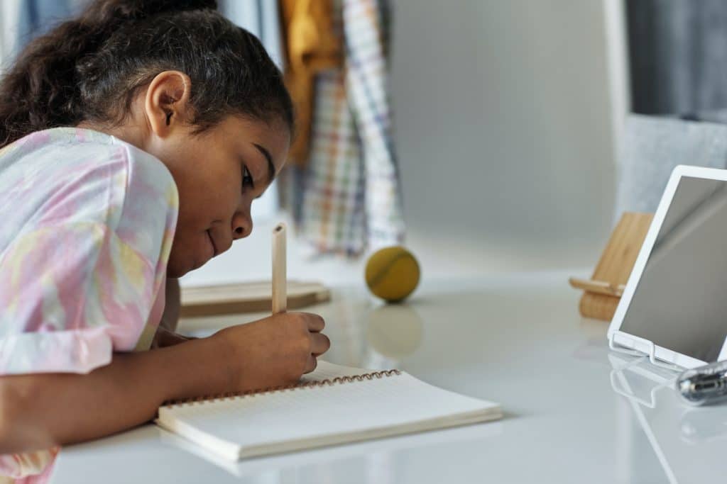 Kids calendar this image shows a child writing on a notebook