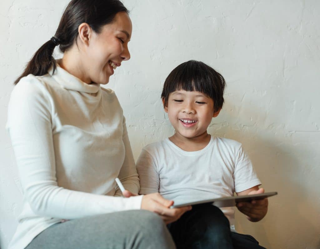 visual support. a mom is helping her son with visual support aids to help him to complete everyday tasks.