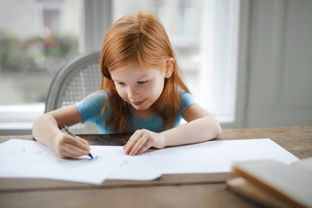 how to focus on homework. A young girl is focusing on her homework.