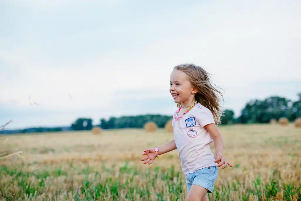 is epilepsy neurodivergent. A girl with epilepsy plays in the grass.