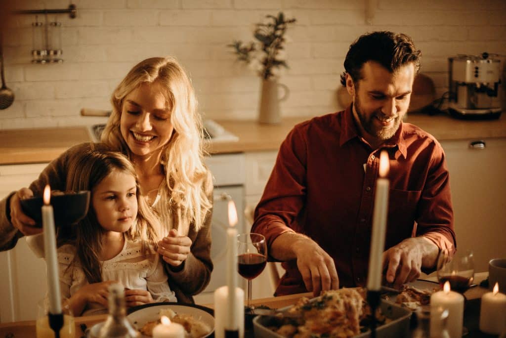 joint attention autism a family is sitting down eating dinner with each other at the table.