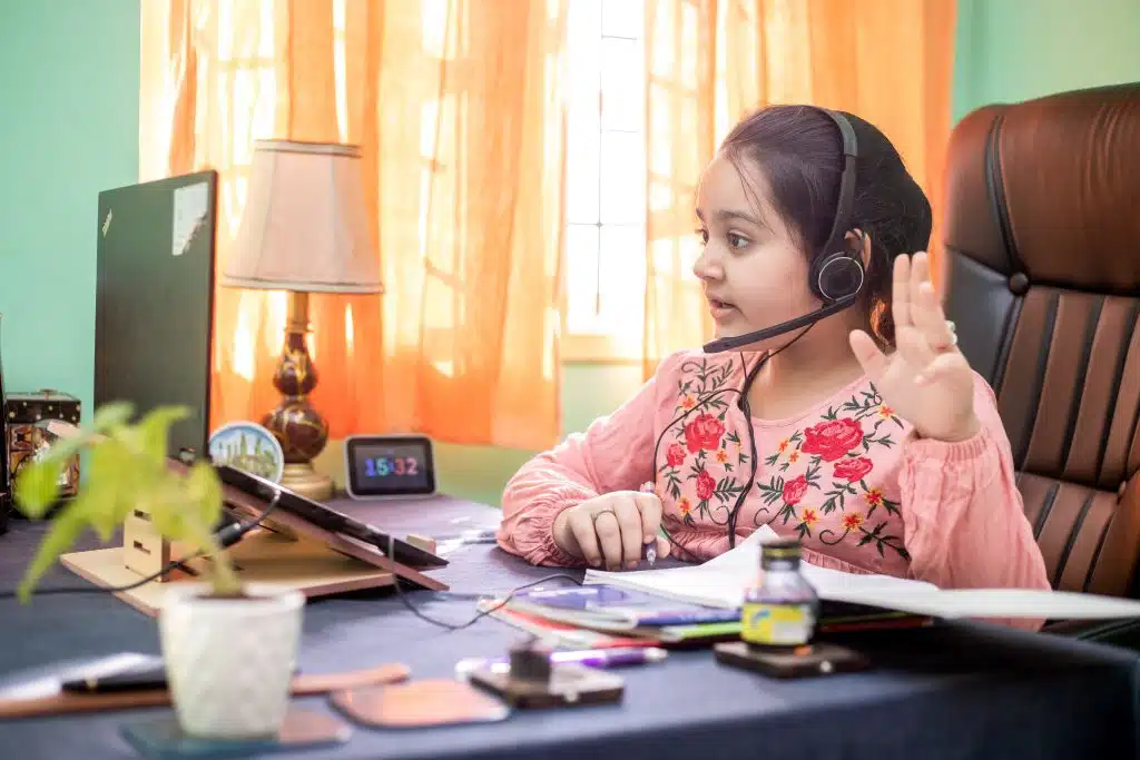 A girl sits at her desk, doing online schooling with software that is one of many examples of assistive technology in the classroom.