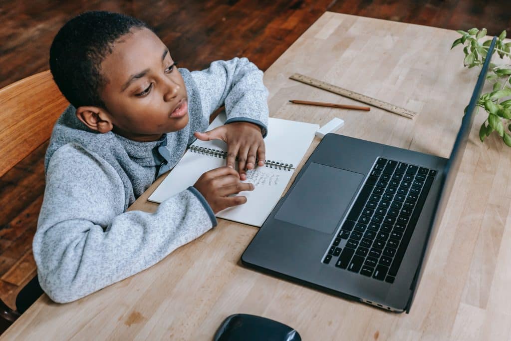 What is the 10 3 rule for ADHD? A young boy sits at his desk with a laptop computer and does his homework.