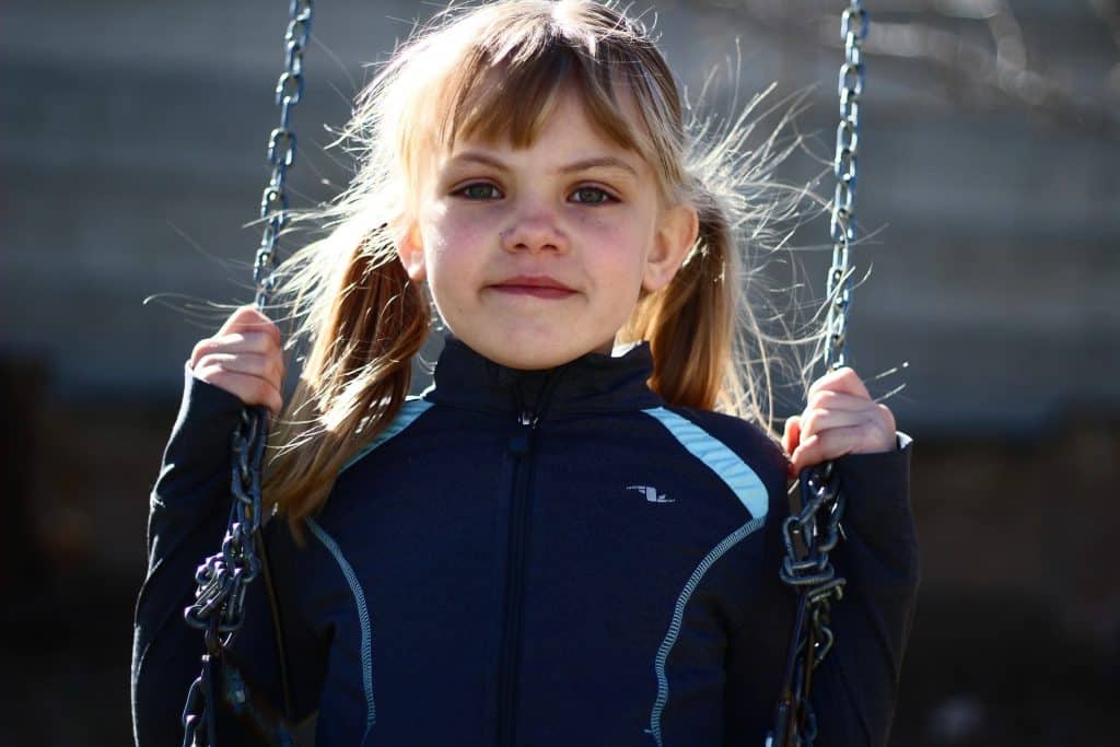 Is a child with ADHD considered special needs? A little girl sits on a swing, and looks into the camera.