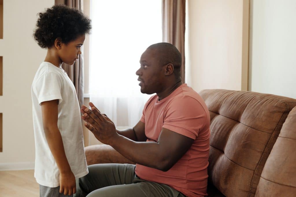 A father talks to his son, setting out guidelines for behavior as part of natural consequences parenting.