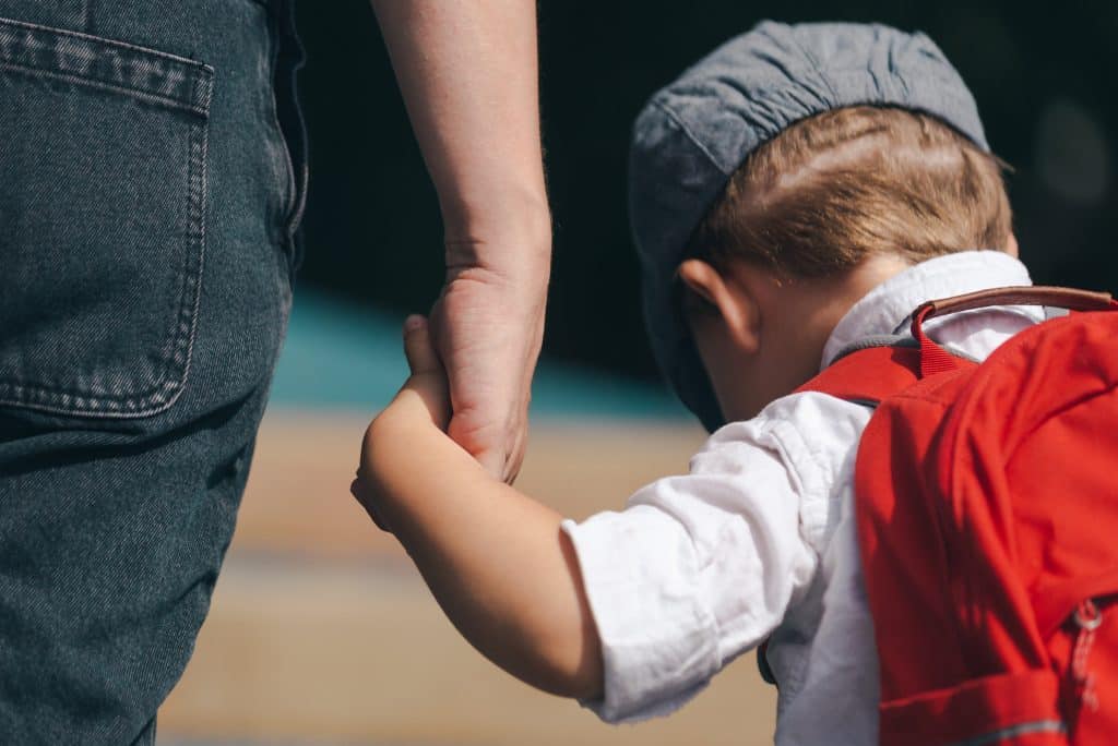 special needs daycare. A boy holds a parent's hand and goes to a special needs daycare.