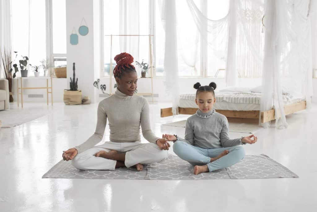 interoception autism. a girl and an adult are doing meditation.