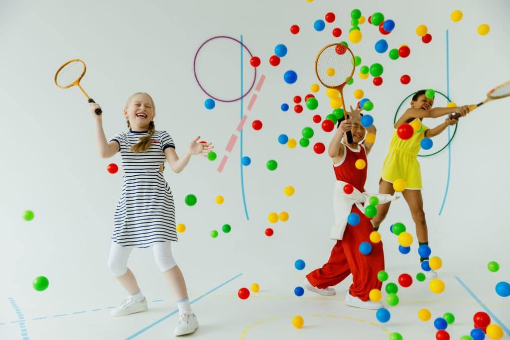 Executive Function Skills by Age. three kids play tennis with colorful balls.