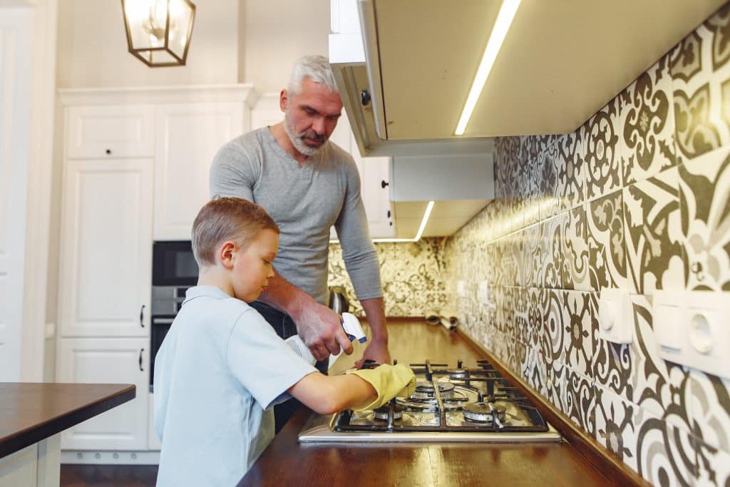 should kids get paid for doing chores little boy cleaning kitchen with father