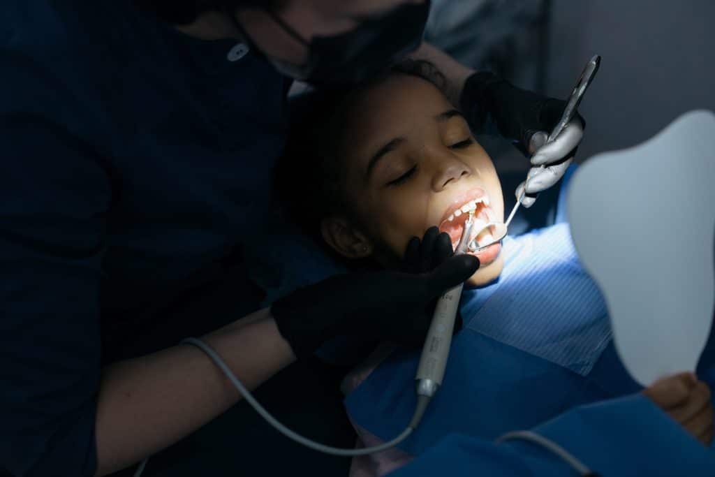 pediatric dentist in houston.  a child is getting her teeth cleaned at the dentist.