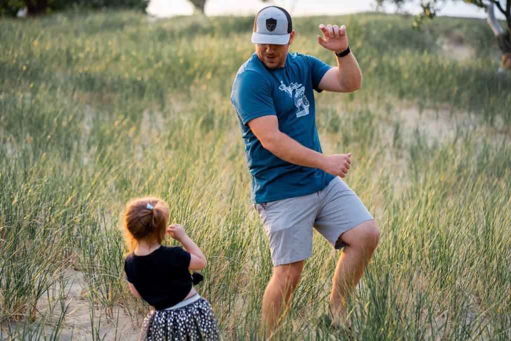 How to dress for warm weather. A dad dances with his daughter in a sunny field.