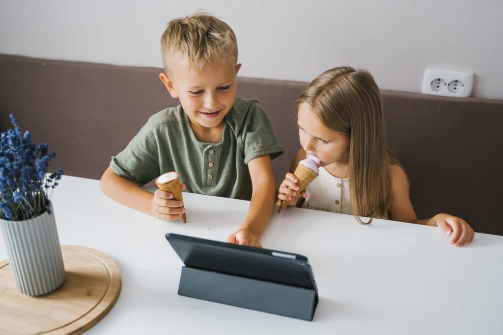 Amazon Tablets Kids. Two kids are playing on their tablet while eating ice cream.