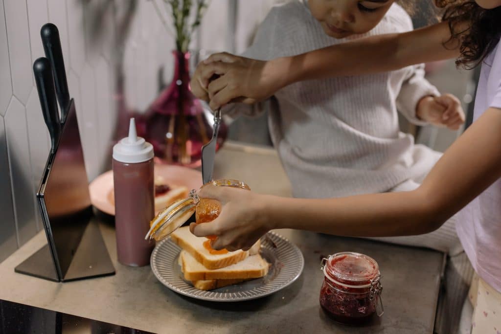 how to make a peanut butter and jelly sandwich. two kids are making a peanut butter and jelly sandwich.