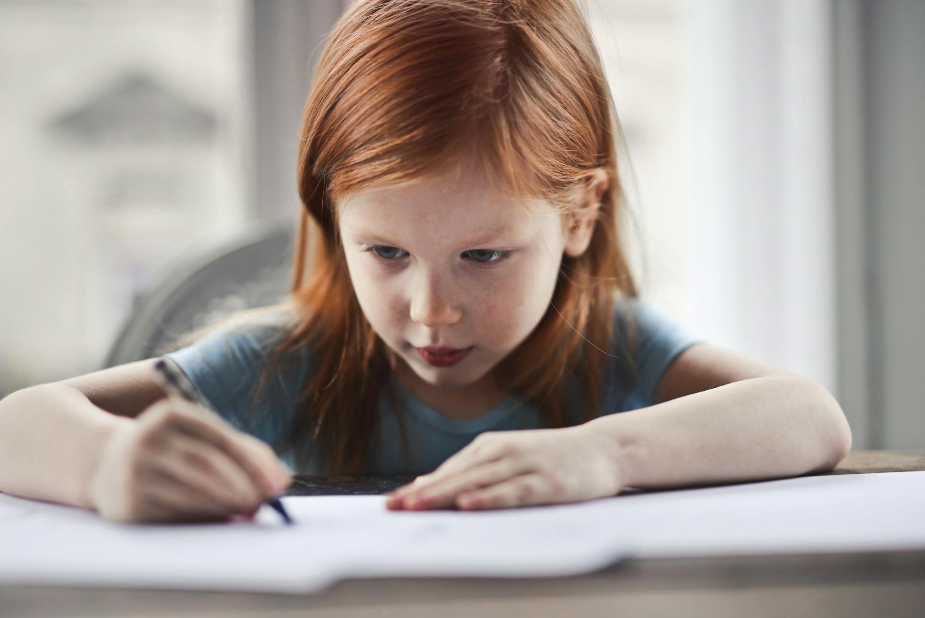 what are the symptoms of dyslexia. girl writing on paper