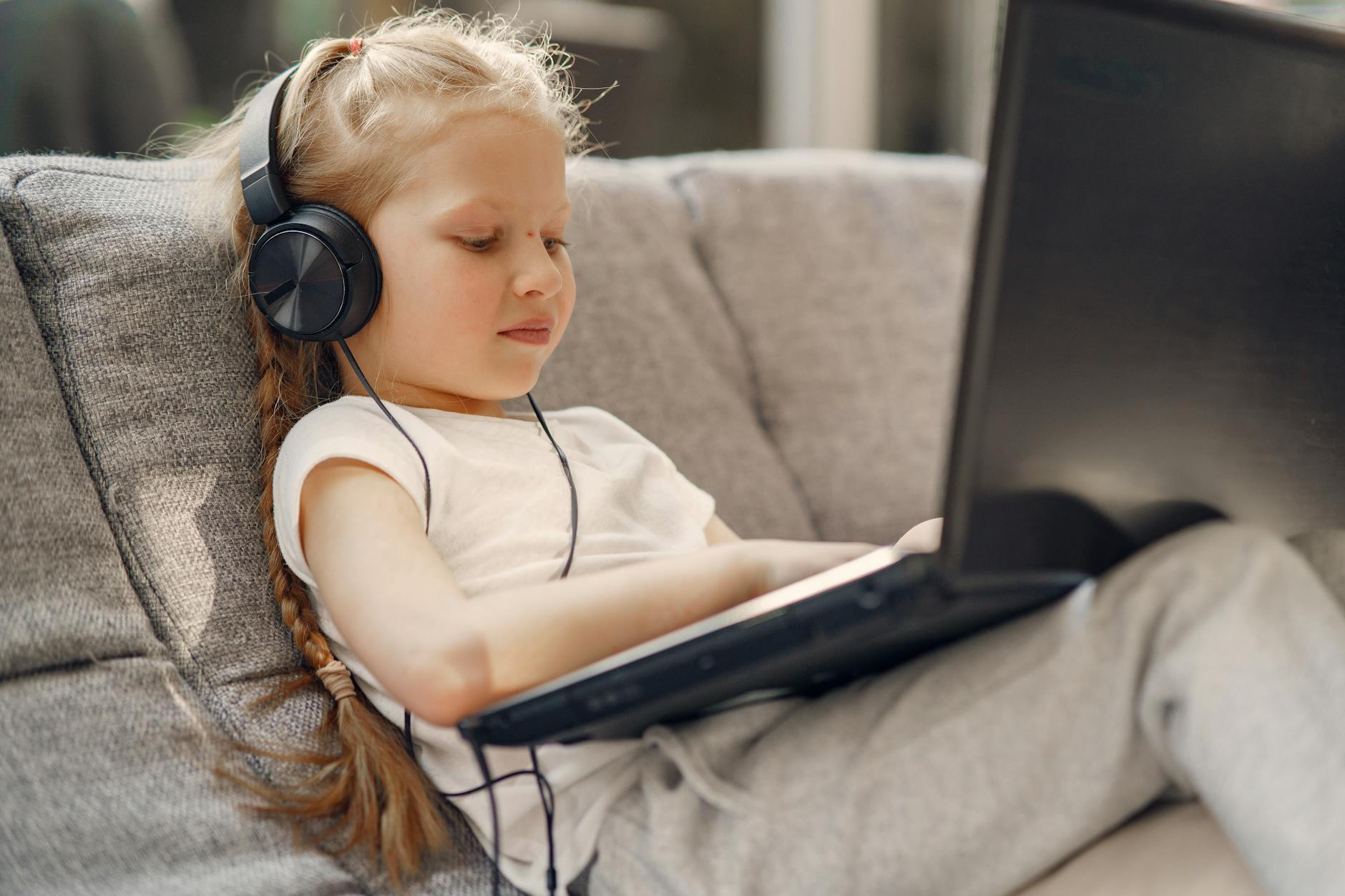 little girl watching movie on laptop