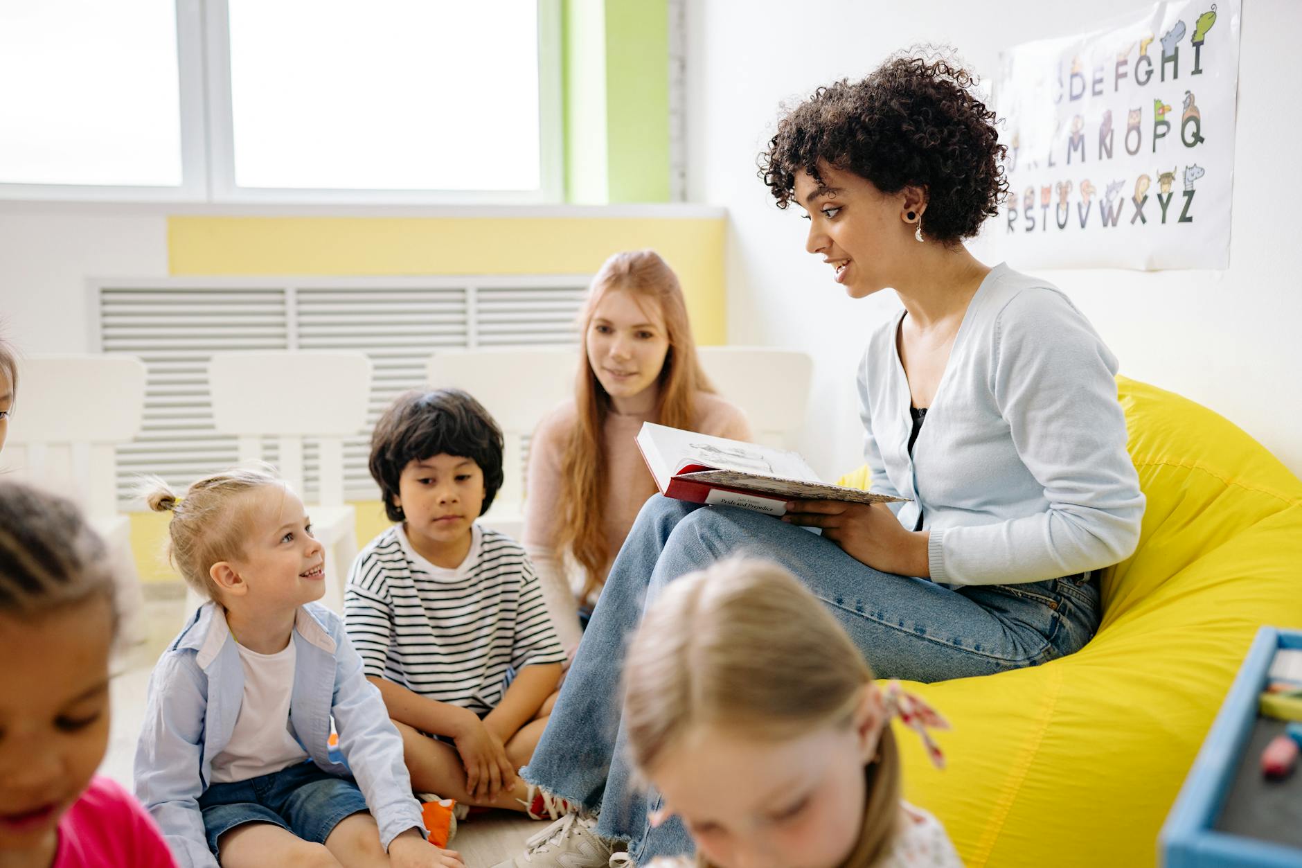 autistic children in daycare. woman reading a book to the children